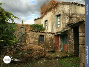 Auf dem Camino Portugues erscheint vieles charmant Das Bild zeigt den ländlichen Camino Portugues: ein altes, im Zerfall befindliches Haus mit türkisfarbenen Türen und Fenstern.