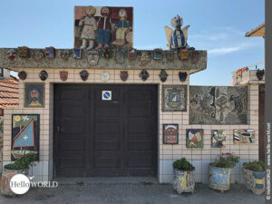 Hier sieht man eine mit lustigen Mosaiken verzierte Fassade eines Hauses bei Vila Cha