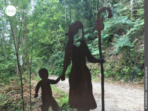 Skulptur aus Stahl auf dem Weg nach Cacheiro: Pilgerin mit Kind Hier sieht man eine metallene Skulptur einer Pilgerin mit Pilgerstab und ihrem Kind im Wald in der Nähe der Ortschaft Cacheiro.