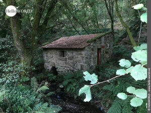 Hier sieht man ein altes nahezu unversehrtes Steinh&auml;uschen am Ufer eines Baches.