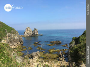 Das Bild zeigt ein Felsenp&auml;rchen an der spanischen Nordk&uuml;ste, das vor blauem Himmel aus dem Wasser ragt.