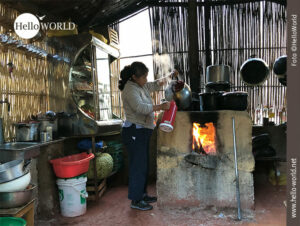 Dies ist ein Foto aus der Serie Bilder aus S&uuml;damerika, das in einer K&uuml;che in einem kleinen Dorf aufgenommen wurde und eine Frau an einem einfachen Holzofen zeigt.