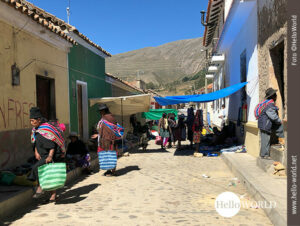 Dieses Foto ist Teil der Serie Bilder aus S&uuml;damerika und zeigt Menschen in der Gasse eines Dorfes, mit Einkaufstaschen in der Hand umhergehen.