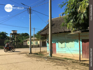 Dies ist ein Foto aus der Serie Bilder in S&uuml;damerika und zeigt eine Stra&szlig;e in einem Dorf, auf der eine Familie Motorrad f&auml;hrt.