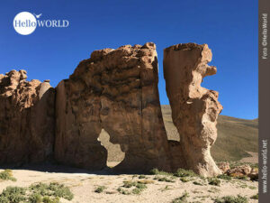 Das Bild von der Altiplano Boliviens zeigt eine gro&szlig;e Felsformation mit einem Loch in der Mitte.