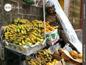 Trotzt dem Regen: Obstverkäuferin am Straßenrand