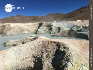 Dieses Bild aus Bolivien zeigt einen Ausschnitt eines Geothermalgebietes mit Schlamml&ouml;chern, vom Schwefel verf&auml;rbte Felsen und Rauch.
