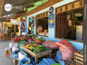 Das Bild aus Rurrenabaque, Bolivien, zeigt den Eingang eines kleinen Supermarktes, vor dem Fr&uuml;chte und Obst ausgelegt sind und in S&auml;cken bereitstehen.