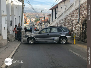 Das Bild von unserer S&uuml;damerika-Tour zeigt ein quer stehendes Auto, das eine schmale Stra&szlig;e in Sucre blockiert.
