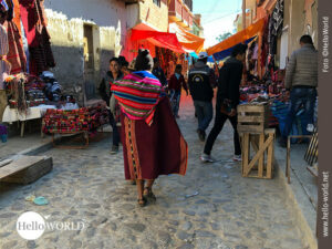Das Bild zeigt einen Mann in einer Gasse von Tarabuco in Bolivien, der die typische Yampara-Kleidung tr&auml;gt.