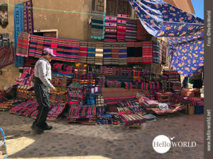 Das Bild vom Sonntagsmarkt in Tarabuco, Bolivien, zeigt einen Stand mit vielen der typischen, bunten Schultert&uuml;chern.