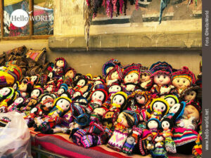 Das Bild eines Stra&szlig;enstandes in Tarabuco, Bolivien, zeigt kleine bunte Stoffpuppen mit drolligen Gesichtern.