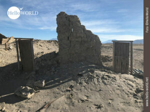 Verfallen: Überreste eines Hauses Das Bild aus Südamerika, Bolivien, zeigt den Rest einer Außenmauer und links und rechts Holztüren mit Rahmen.