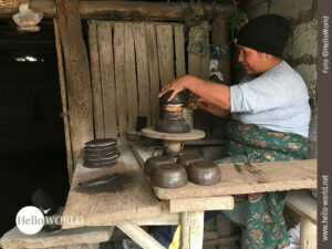 Das Bild aus Ecuador zeigt die Begegnung mit einer T&ouml;pferin, die vor ihrem T&ouml;pfertisch sitzt und t&ouml;pfert.