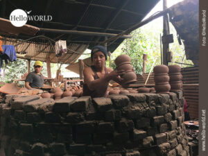 Das Bild aus einer T&ouml;pferei in Ecuador zeigt einen Mann, der in einem gro&szlig;en runden Ofen steht und T&ouml;pferware hineinstellt.