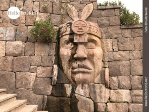 Dieses Bild stammt aus Chivay, Peru, und zeigt einen in Stein gehauenen Indianerkopf an einer Steinmauer.