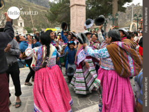 Das Bild aus Chivay, Peru, zeigt eine Gruppe von Menschen in Trachten, die fr&ouml;hlich feiern und H&uuml;te in die Luft werfen.