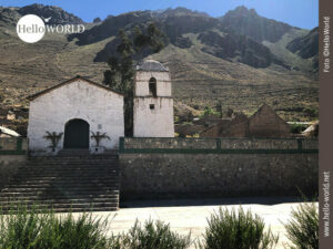 Dieses Bild aus Malata, Colca Canyon, zeigt eine kleine wei&szlig;e Kirche, zu der Treppen hinauf f&uuml;hren und deren T&uuml;r mit Kreuzen geschm&uuml;ckt ist.