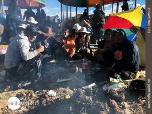 Coole Truppe: Junge PeruanerInnen feiern das Sonnenfest Das Bild zeigt eine Gruppe junger PeruanerInnen, die auf dem Sonnenfest feiern und um Essen und Getränke herumsitzen.