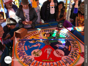 W&auml;hrend eines Volksfestes in Cusco, Peru, ist dieses Bild entstanden, auf dem man ein buntes Roulette sieht um das junge und alte Zuschauer stehen.