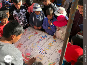 Die Spannung steigt beim Kartenspiel Auf diesem Bild von einem Volksfest in Cusco, Peru, sieht man Kinder um ein Kartenspiel herumstehen und gespannt auf den Tisch blickend.