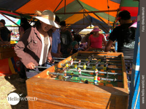 Dieses Bild von einem Volksfestes in Cusco, Peru, zeigt eine Frau mit Sonnenhut beim Fischfu&szlig;ball.