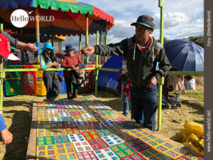 Dieses Bild wurde w&auml;hrend eines Volksfestes in Cusco, Peru, aufgenommen und zeigt einen Jungen vor einem Wurfspiel, dahinter zwei Frauen.