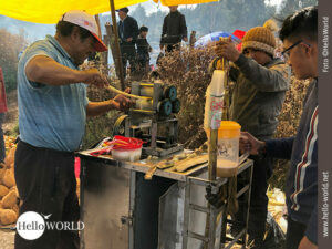 Dieses Bild vom Sonnenfest in Cusco, Peru, zeigt einen Mann der an einer Maschine Zuckerrohr presst.