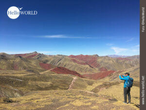Dieses Bild aus Peru zeigt wie ein Wanderer gerade die roten Berge des Red Valley in Peru fotografiert.