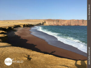 Playa Roja: der rote Strand im Nationalreservat Paracas Dieses Bild aus dem Nationalreservat Paracas zeig einen rot-braun gefärbten Strand, der ivon beigefarbenen Sand und türkisfarbenem Wasser umgeben ist.