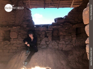 Zu Besuch in den Inka-Ruinen in Pisaq Dieses Bild wurde in einem zerfallenen Gebäude bei den Inka-Ruinen in Pisaq, Peru, aufgenommen und zeigt Andrea vor einer Mauer sitzend.